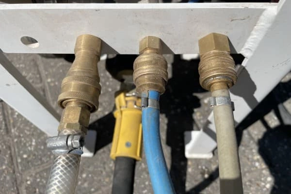 Sluit de water- en stuurslangen aan.